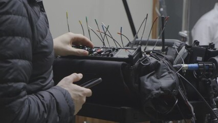 Audio Technician Adjusting Sound Mixer and Recording Equipment