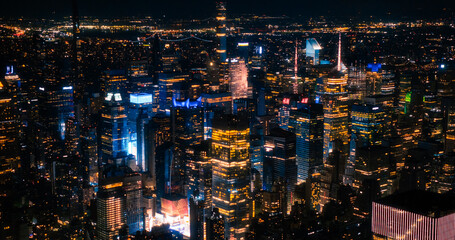 Aerial Image of Office Buildings at Night. Rooms Have Lights On, Businesspeople and Managers Working Long Hours in New York City. Helicopter Cityscape View of Manhattan in the Evening