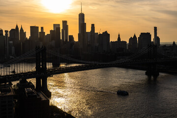 New York City Skyline Aerial Photo from a Helicopter at Sunset. Famous Skyscraper Buildings with Manhattan Bridge. Busy Diverse Megapolis with Cars, Boats and People Moving Around