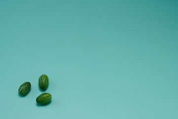 マイクロきゅうりを数粒左下に配置した緑色系背景あり俯瞰撮影