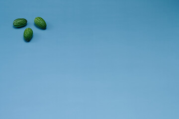 マイクロきゅうりを数粒左上に配置した青色系背景あり俯瞰撮影