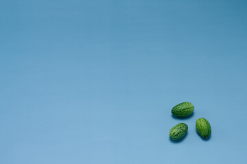 マイクロきゅうりを数粒右下に配置した青色系背景あり俯瞰撮影