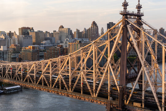 New York City Cityscape at Sunset. Aerial Image from a Helicopter. Historic Ed Koch Queensboro Bridge Architecture. Focus on Engineering Details of the Bridge