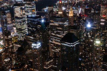 Fototapeta na wymiar Aerial View of Manhattan Architecture at Night. Evening Shot of Financial Business District from a Helicopter. Scenery of Historic Office Towers, Illuminated Skyscrapers