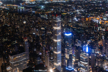 Helicopter Tour of New York City Architecture at Night. Fly-By Over Midtown Manhattan Office Buildings and Skyscrapers. Aerial Urban Landscape with Lights at Night