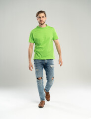 Full length portrait of happy handsome young man in green t-shirt isolated on white background.