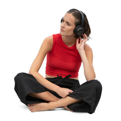 Woman with headphones in relaxed outfit sitting on the floor and listening to music