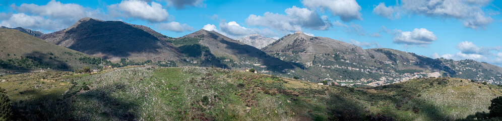 Fototapeta na wymiar Extra large panoramic view over the rough mountains with houses and blue sky around Cannizzaro-Favare, Italy