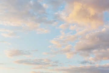 Beautiful fluffy clouds painted in pastel colors at sunrise. Multicolor sky atmosphere background...