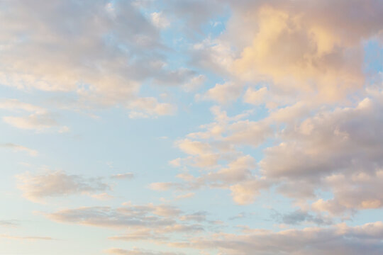 Beautiful fluffy clouds painted in pastel colors at sunrise. Multicolor sky atmosphere background or wallpaper