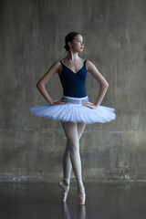 Young ballerina in a white tutu stands