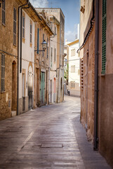 an alleyway with buildings and signs in front of it, Mallorca