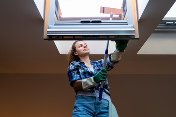 Cleaning service worker woman cleans skylight window.