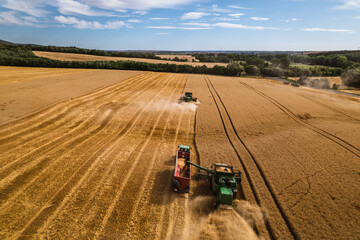 Aerial view of a tractor and harvester working in a field. Agriculture and cultivation of...