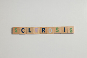 The inscription sclerosis in wooden letters on a white background