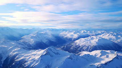 Fototapeta na wymiar Aerial shot of a serene mountain range with snow-capped peaks and valleys.