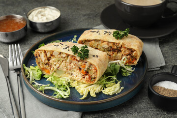 Pieces of delicious strudel with chicken and vegetables served on grey textured table, closeup