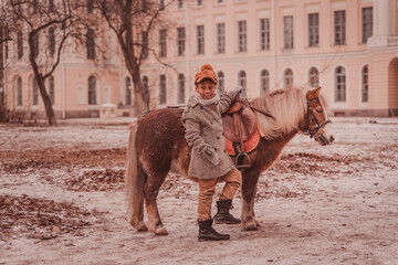 Naklejka premium the boy is about to sit in the saddle looking back