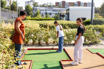 golfers with parents playing golf at sunny day