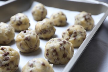 Baking pan with raw chocolate chip cookie balls, closeup
