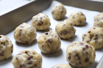 Baking pan with raw chocolate chip cookie balls, closeup
