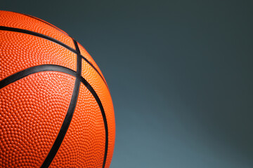 One orange basketball ball on dark grey background, closeup. Space for text