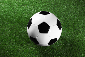 Fototapeta premium One soccer ball on green grass. Sports equipment