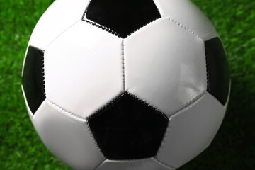 One soccer ball on green grass, closeup. Sports equipment