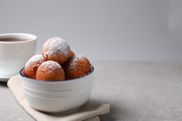 Delicious sweet buns in bowl on gray table, space for text