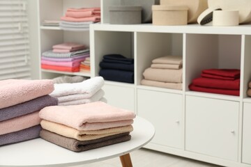 Stacked towels, decorative boxes and colorful bed linens in shop