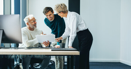 Three business people having a discussion as a team in an office