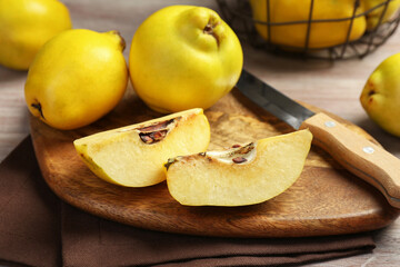 Naklejka na ściany i meble Ripe whole and cut quinces with knife on table, closeup