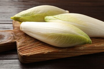 Raw ripe chicories on wooden table, closeup
