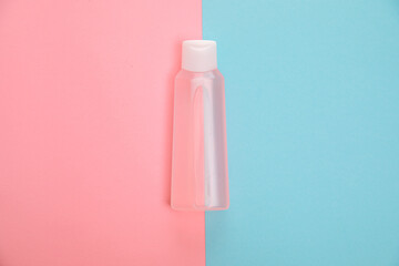 Blank transparent cosmetic bottle on pink and blue background. Branding mock-up for lotion, cream, gel, foam, soap or shampoo. Symmetrical composition. Beauty blogger concept. - obrazy, fototapety, plakaty
