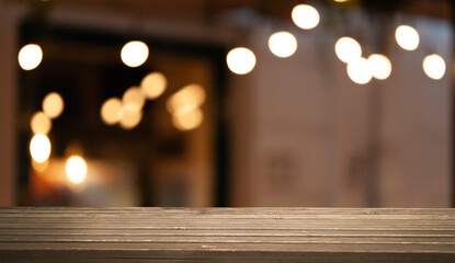 Empty dark wooden table in front of restaurant abstract blurred bokeh background. can be used to demonstrate or mount your products. Layout for space