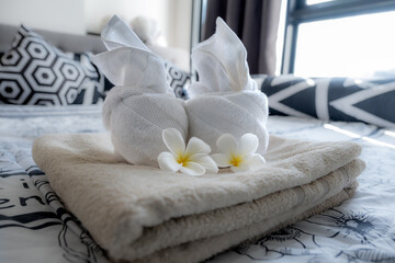 Plumeria and towels on the bed in the luxury hotel room ready for tourist travel