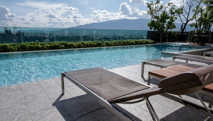 Picture of a sun bed chair on the edge of a hotel or resort rooftop swimming pool