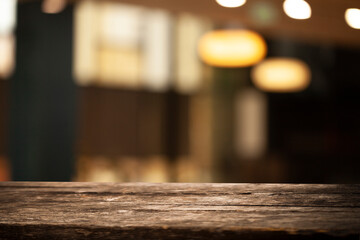 Empty dark wooden table in front of restaurant abstract blurred bokeh background. can be used to demonstrate or mount your products. Layout for space