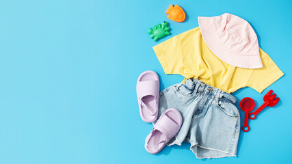 A set of children's summer clothes and toys for the beach. Stylish clothes for a girl. Summer vacation. Copy space