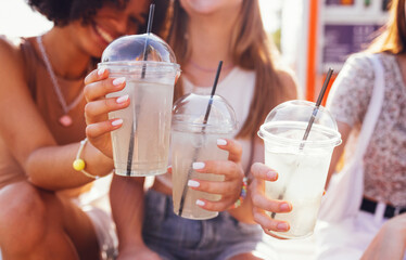 Close up of three teenage girls in casual clothes drinking tasty lemonade on the go