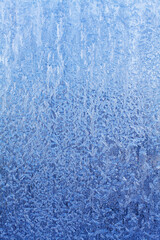 Fototapeta na wymiar blue frosty patterns on frozen window glass