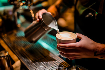 Fototapeta na wymiar bartender's hands preparing a delicious cappuccino, close up