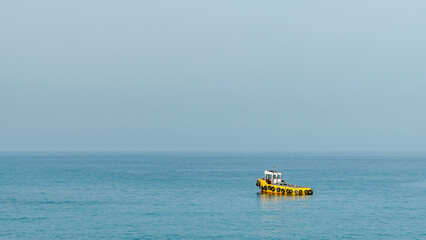Yellow tugboat in the Mediterranean Sea. Minimal background.