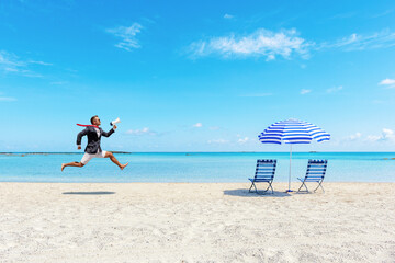 Happy businessman running on the tropical beach with megaphone. Summer vacation concept.