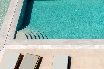 Top view of swimming pool with sunbeds. Summer backround.