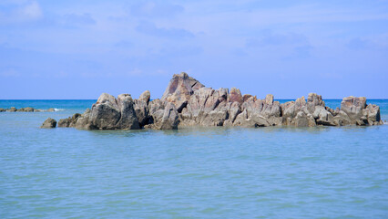 Fototapeta premium Charming Natural View Of Piles Of Rock Formations In The Middle Of Blue Sea Water, On Tanjung Kalian Beach, Indonesia
