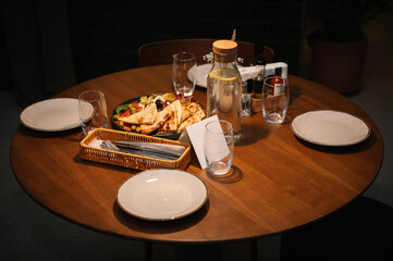 Served dinner table for four people in cafe interior. Event festive dinner. Delicious dishes on the table in the restaurant. Serving table with food, birthday setting. Side view. Setup table.