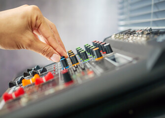 Close-up of sound engineer hands adjusting control sound mixer in recording, broadcasting...