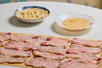 Pork tenderloin thinly sliced and prepared for schnitzel before cooking.