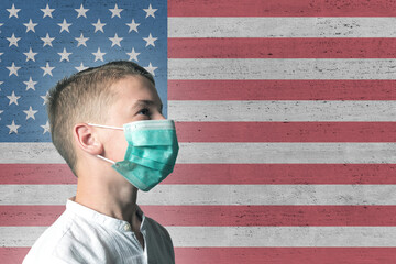 Boy in a medical mask on his face on background of USA flag . Epidemic virus 2019-nCoV Respiratory...